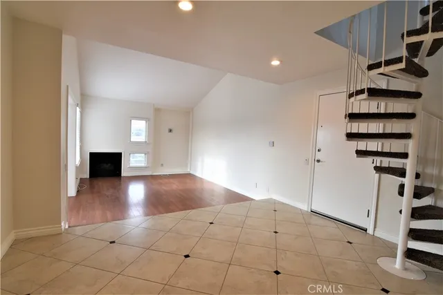 a view of a livingroom with wooden floor and staircase