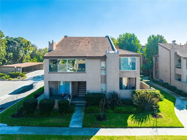 an aerial view of a city with lots of residential buildings and ocean view in back