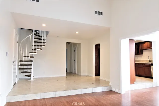 an empty room with wooden floor and entryway