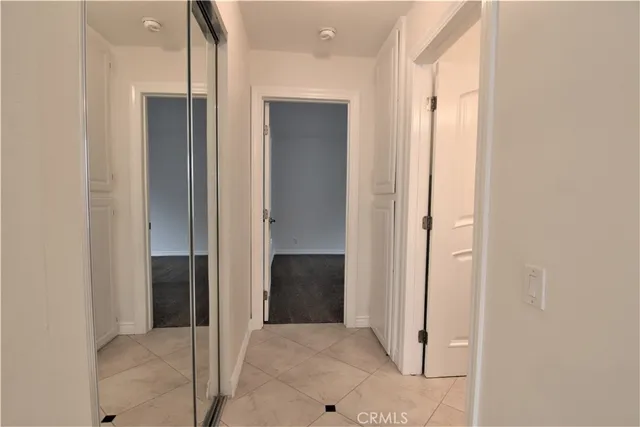a view of a hallway with closet and bathroom