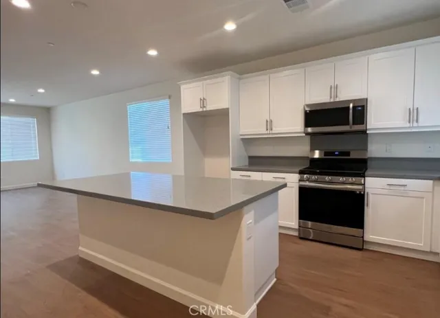 a kitchen with granite countertop a stove and a sink