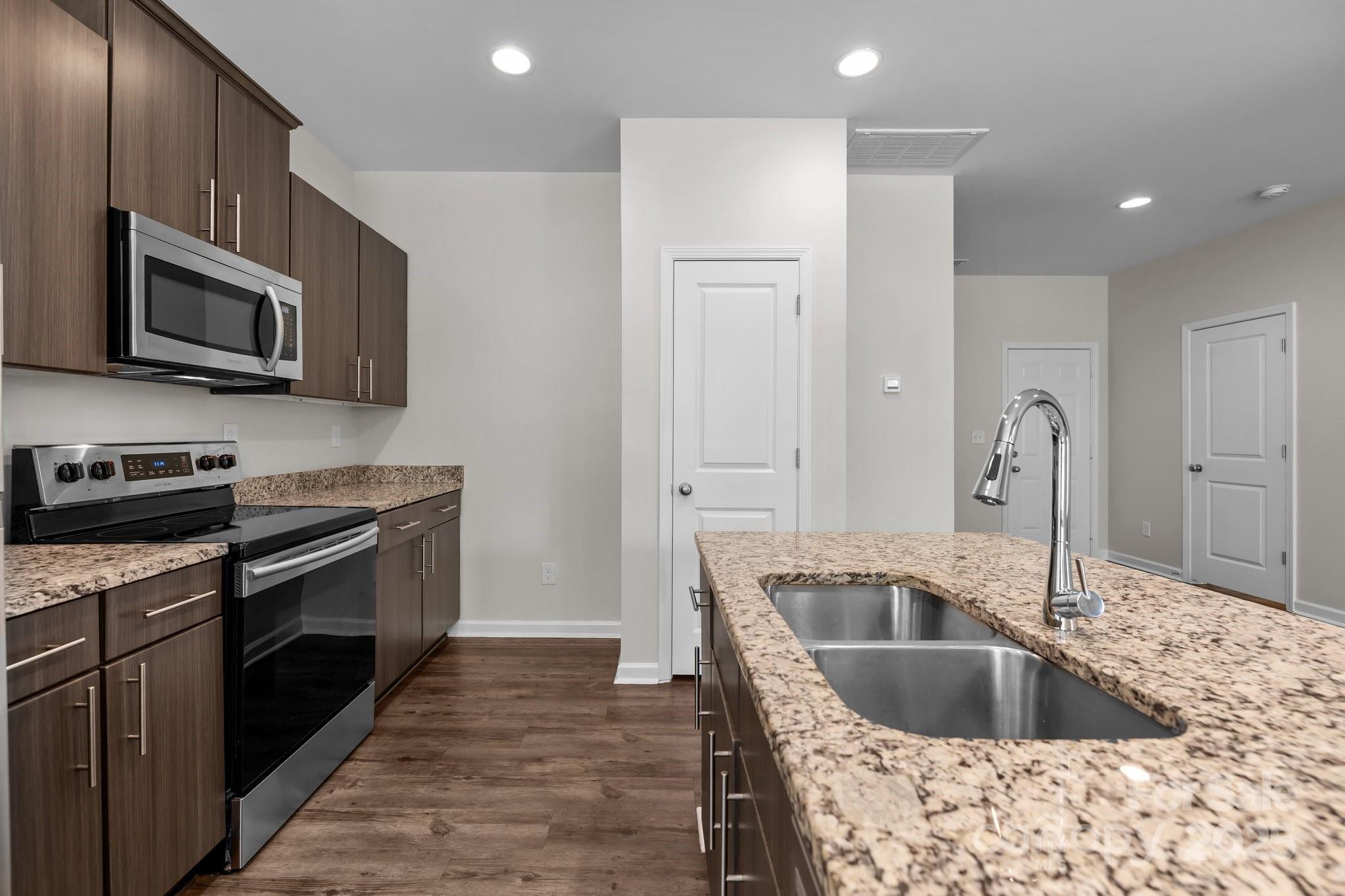 206 Overstone Court Fort Mill, SC 29715 - Photo 20 of 47 a kitchen with stainless steel appliances granite countertop a sink and a stove top oven with wooden floor