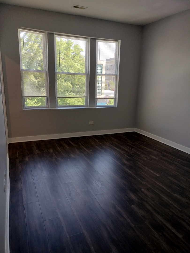 1943 West 48th Street, Unit 2 Chicago, IL 60609 - Photo 13 of 30 an empty room with wooden floor and windows