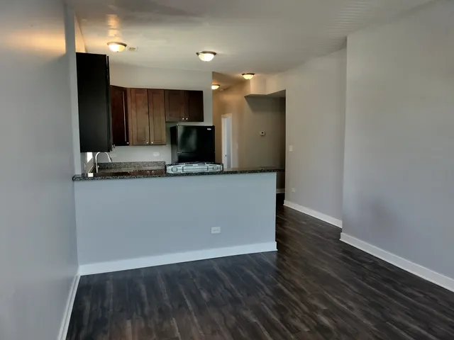 a view of kitchen with stainless steel appliances granite countertop cabinets and wooden floor