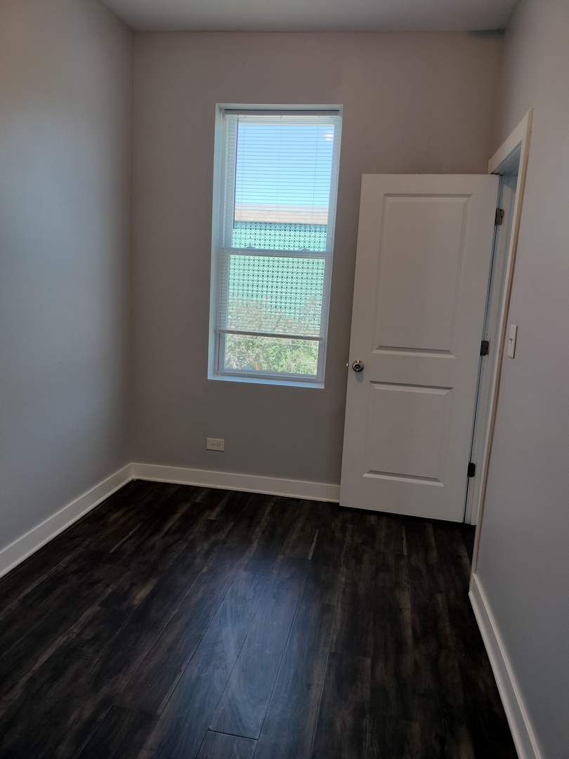 1943 West 48th Street, Unit 2 Chicago, IL 60609 - Photo 23 of 30 a view of an empty room with wooden floor and a window