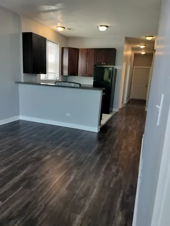 a view of a kitchen with a sink and a refrigerator