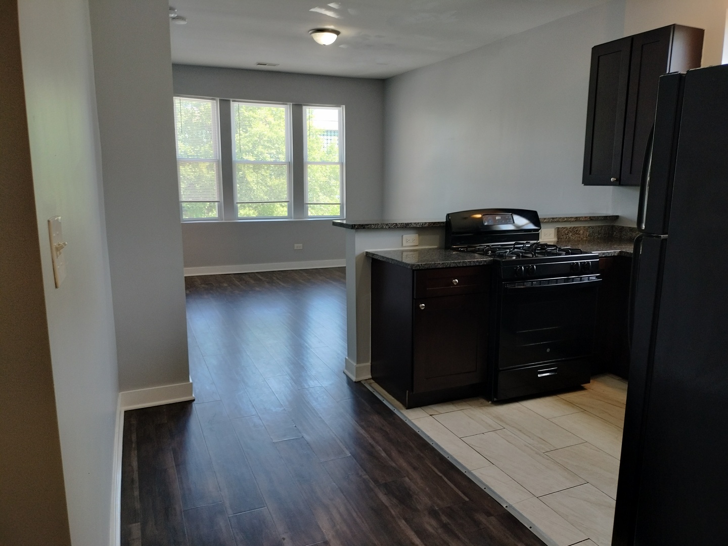 1943 West 48th Street, Unit 2 Chicago, IL 60609 - Photo 5 of 30 a kitchen with a wooden floor and black white walls