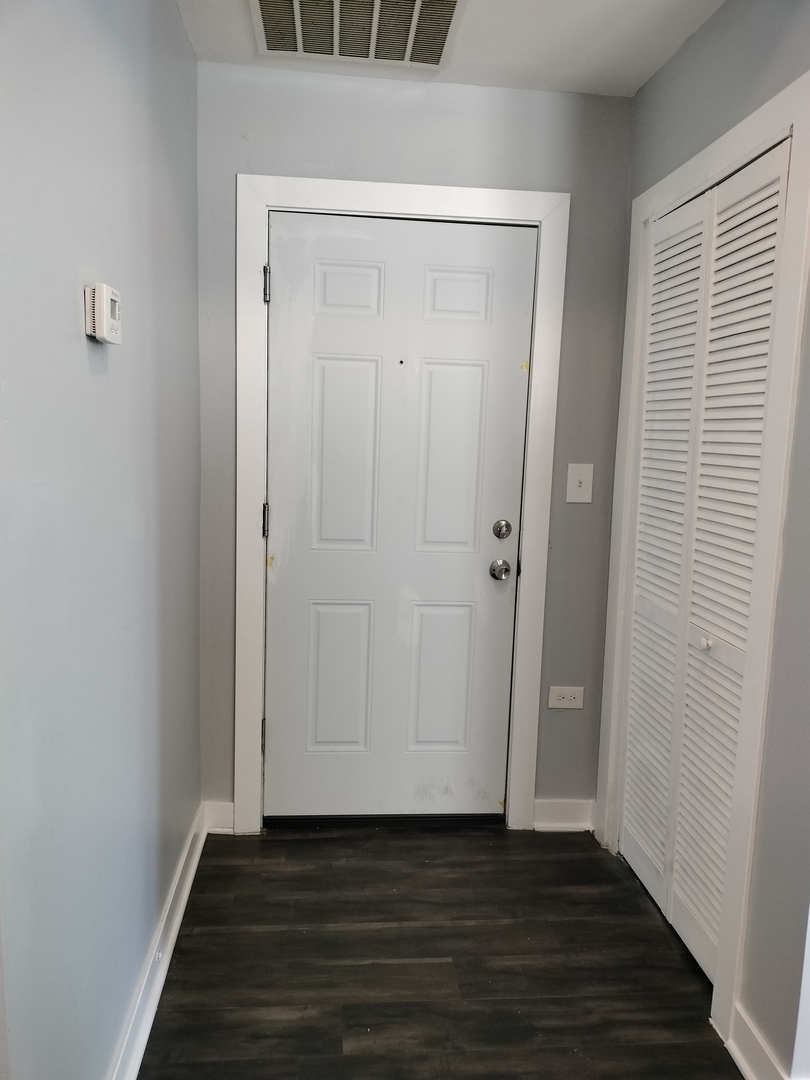 1943 West 48th Street, Unit 2 Chicago, IL 60609 - Photo 7 of 30 a view of an empty room with wooden floor and a window