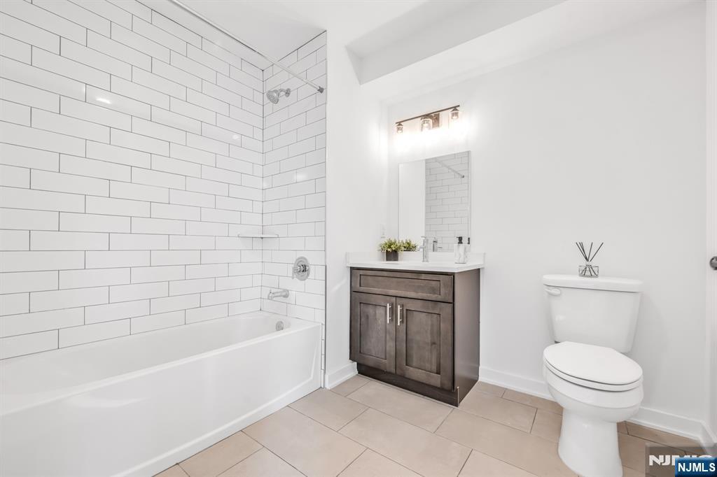 315 Railroad Avenue, Unit 108 East Rutherford, NJ 07073 - Photo 13 of 28 a bathroom with a bathtub a sink a toilet and mirror