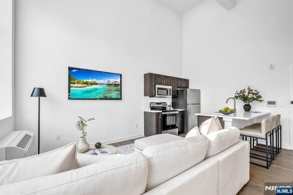 315 Railroad Avenue, Unit 108 East Rutherford, NJ 07073 - Photo 5 of 28 a living room with furniture and a flat screen tv