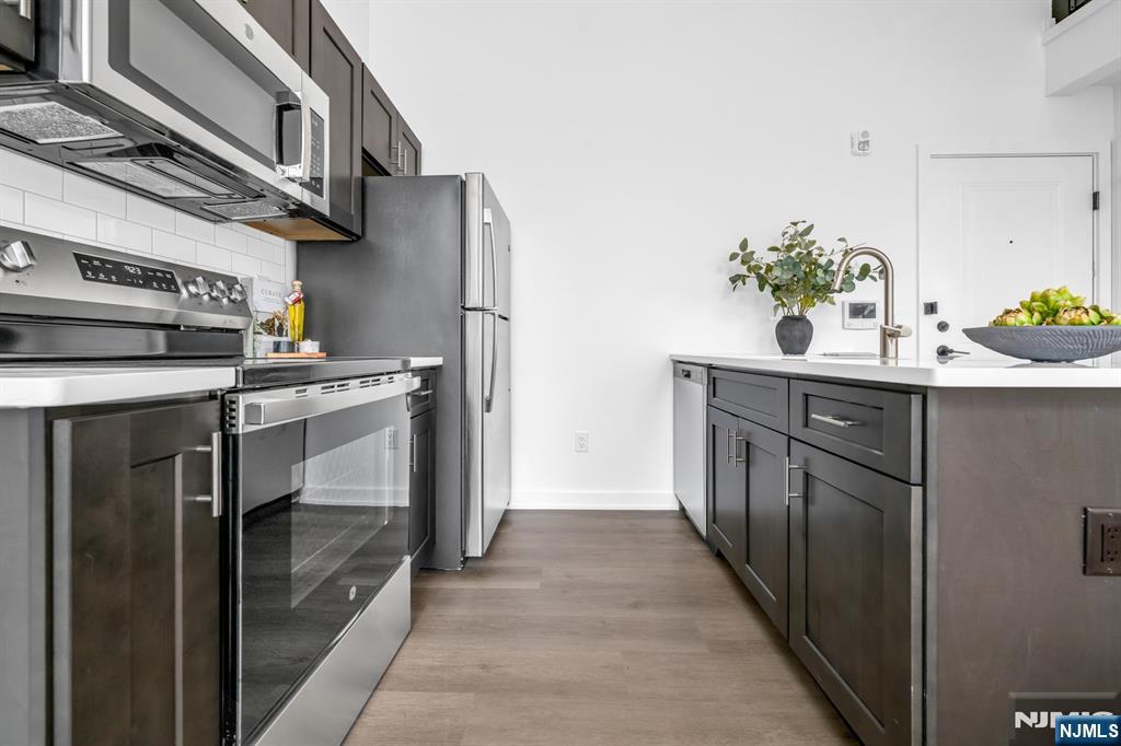 315 Railroad Avenue, Unit 108 East Rutherford, NJ 07073 - Photo 9 of 28 a kitchen with stainless steel appliances a sink and a refrigerator