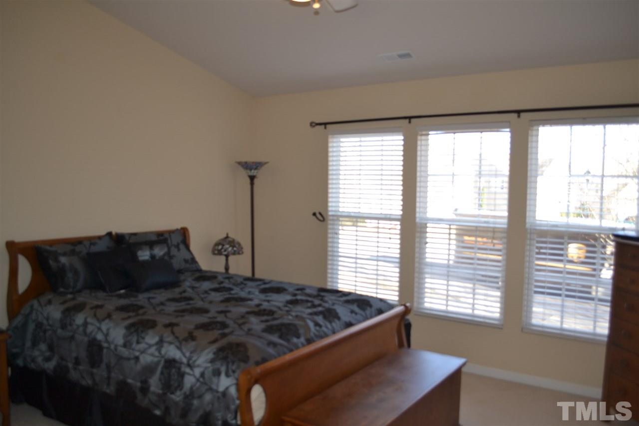 7725 Tanby Court Raleigh, NC 27613 - Photo 14 of 25 a bed sitting in a bedroom next to a window
