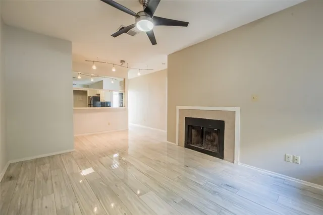wooden floor fireplace and windows in an empty room
