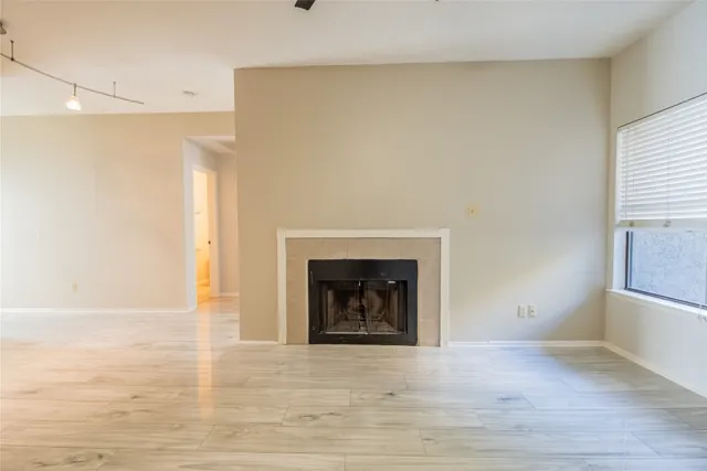 a view of an empty room with a fireplace and a window