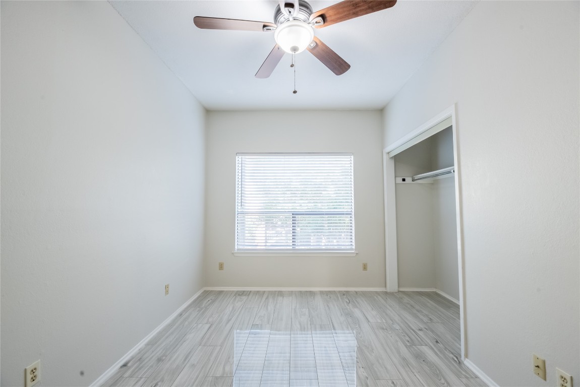 806 West 24th Street, Unit 236 Austin, TX 78705 - Photo 8 of 15 an empty room with chandelier fan and windows