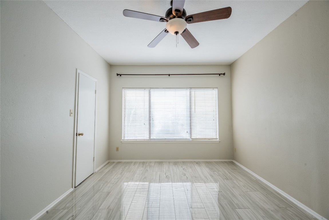 806 West 24th Street, Unit 236 Austin, TX 78705 - Photo 10 of 15 an empty room with wooden floor ceiling fan and windows
