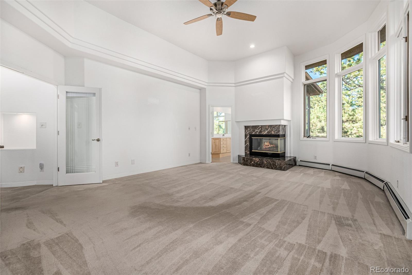 941 Sleepy Hollow Road Golden, CO 80401 - Photo 20 of 50 an empty room with a fireplace and windows