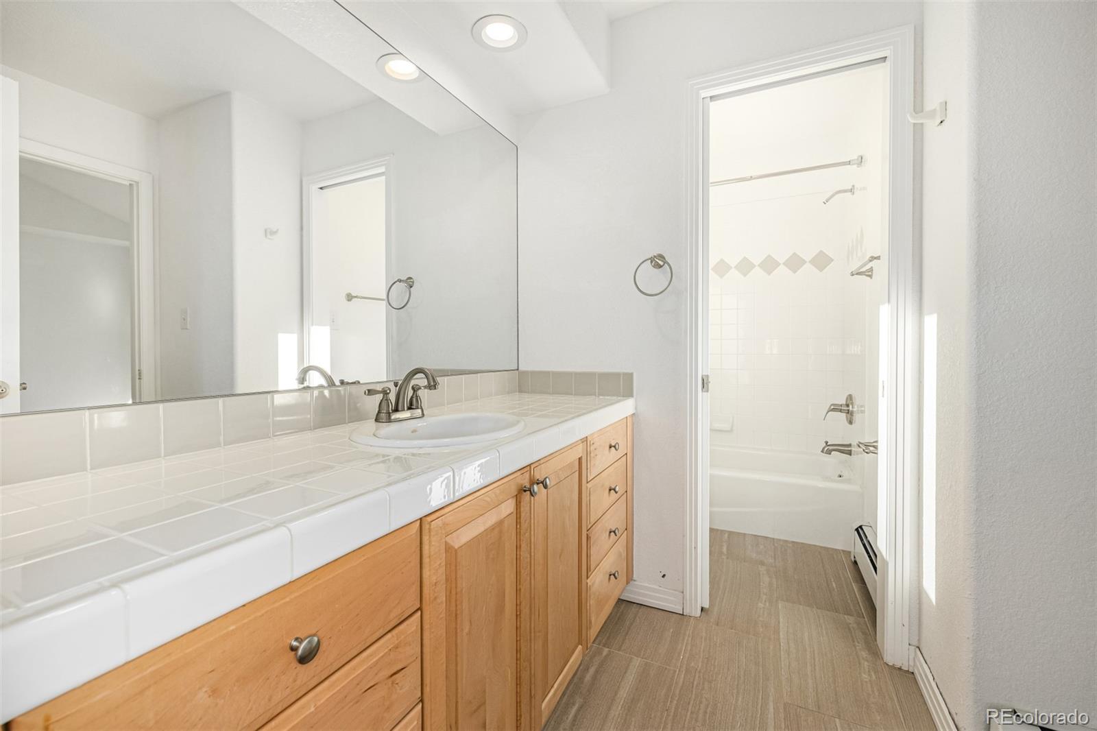 941 Sleepy Hollow Road Golden, CO 80401 - Photo 26 of 50 a bathroom with a granite countertop sink a mirror and a bathtub
