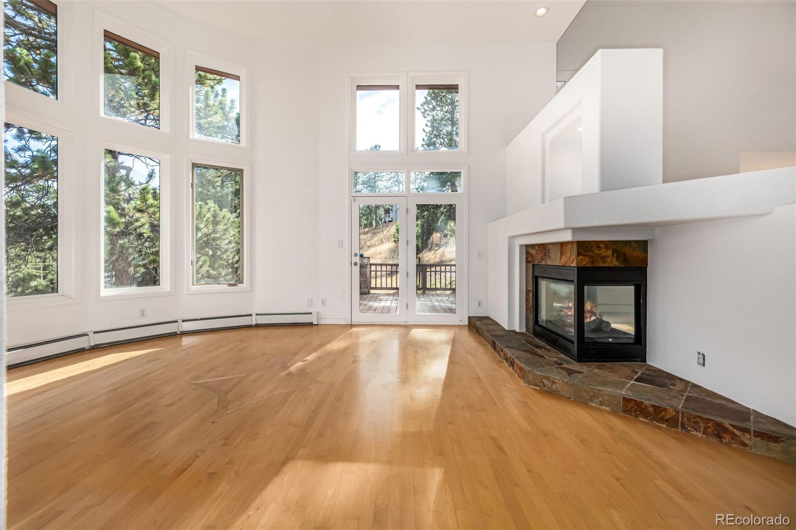 941 Sleepy Hollow Road Golden, CO 80401 - Photo 5 of 50 an empty room with wooden floor and windows