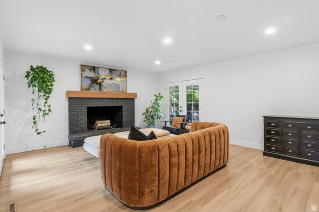 4150 Dover Lane Provo, UT 84604 - Photo 15 of 44 Living area featuring a dark brick fireplace with a wood mantel, light wood-finish flooring, recessed lighting, and white walls