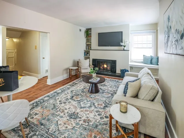 a living room with furniture a flat screen tv and a fireplace