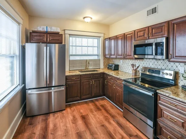 a kitchen with stainless steel appliances granite countertop a refrigerator stove top oven a sink and dishwasher