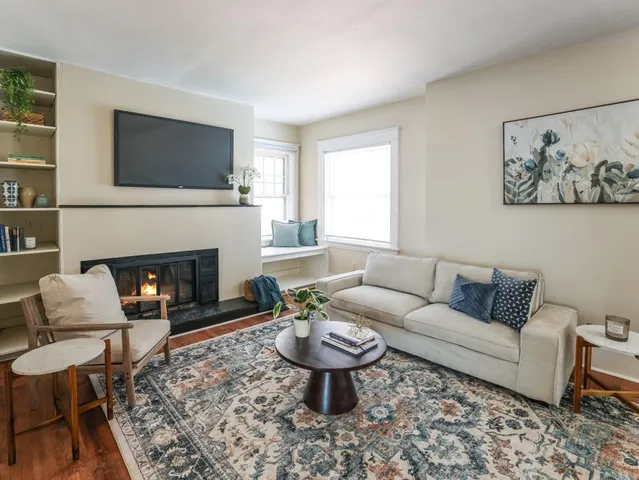 a living room with furniture a flat screen tv and a fireplace