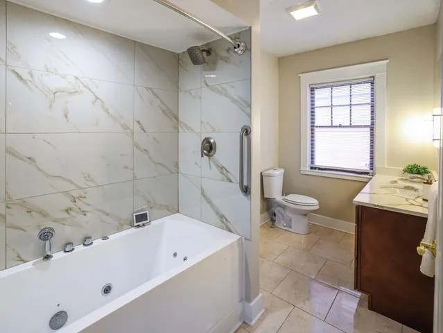 a bathroom with a tub a sink and a window