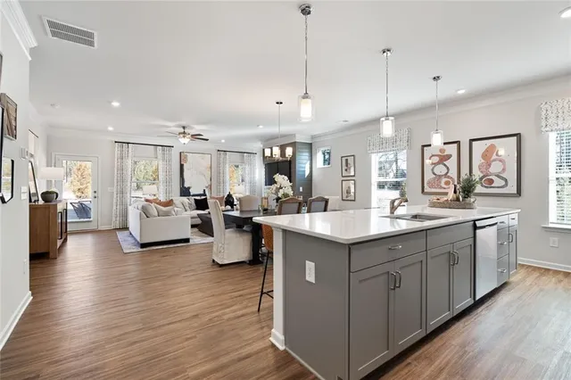 a kitchen with stainless steel appliances granite countertop a dining table chairs refrigerator sink and cabinets