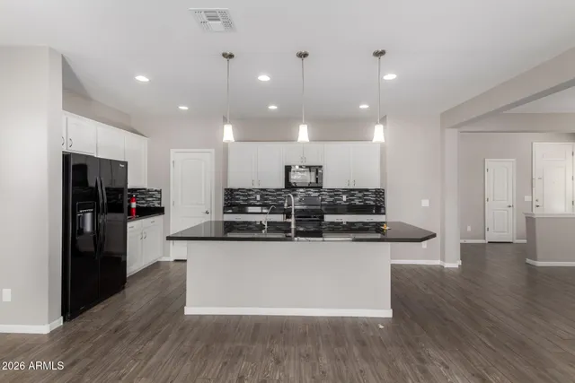 a large kitchen with stainless steel appliances kitchen island a large counter top and a wooden floors