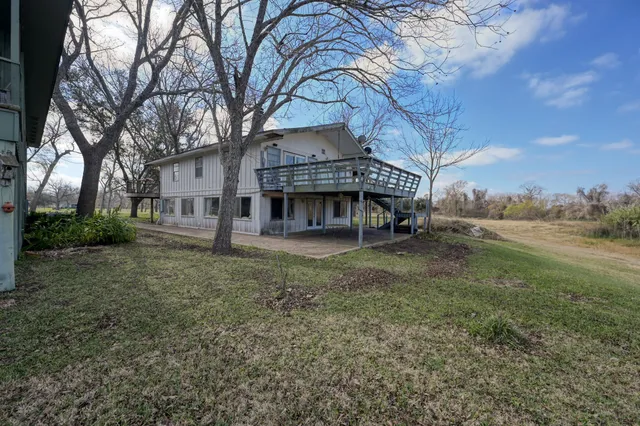 a view of a house with a yard and large tree