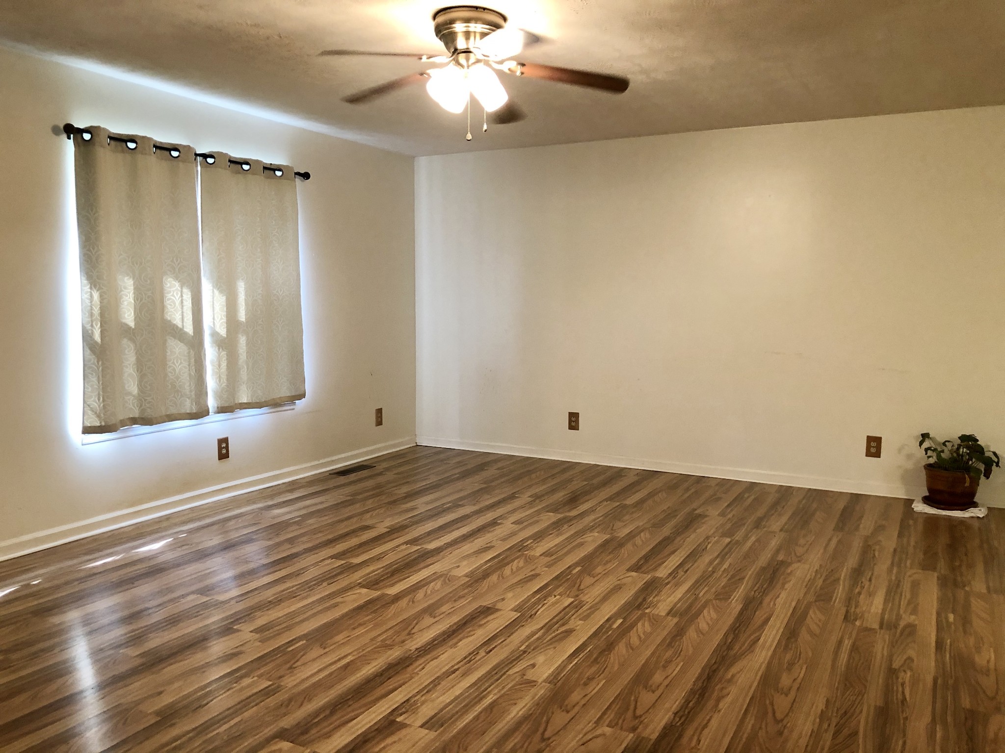 1480 Swan Mill Road Morrison, TN 37357 - Photo 3 of 26 an empty room with wooden floor fan and windows