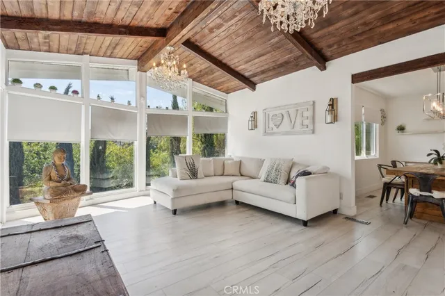 a living room with furniture wooden floor and a large window