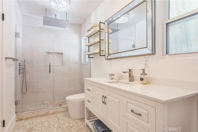 a bathroom with a sink a toilet and shower