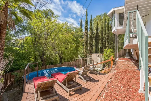 a view of a patio with table and chairs with wooden floor and fence