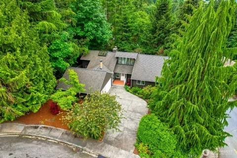 an aerial view of a house with a yard and large tree