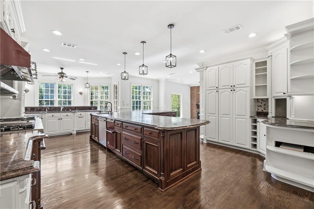2240 Wilzman Trail Conyers, GA 30012 - Photo 12 of 72 a large kitchen with stainless steel appliances granite countertop a lot of counter space and wooden floors