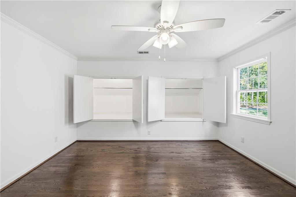 2240 Wilzman Trail Conyers, GA 30012 - Photo 32 of 72 an empty room with wooden floor chandelier fan and windows
