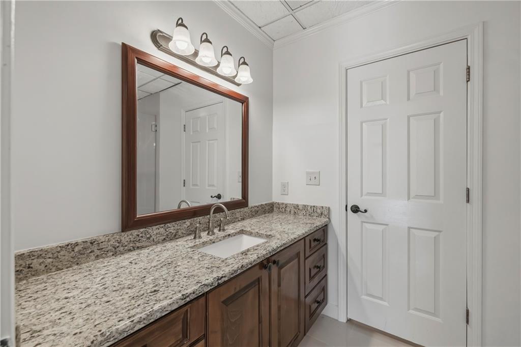 2240 Wilzman Trail Conyers, GA 30012 - Photo 46 of 72 a bathroom with a granite countertop sink and a mirror