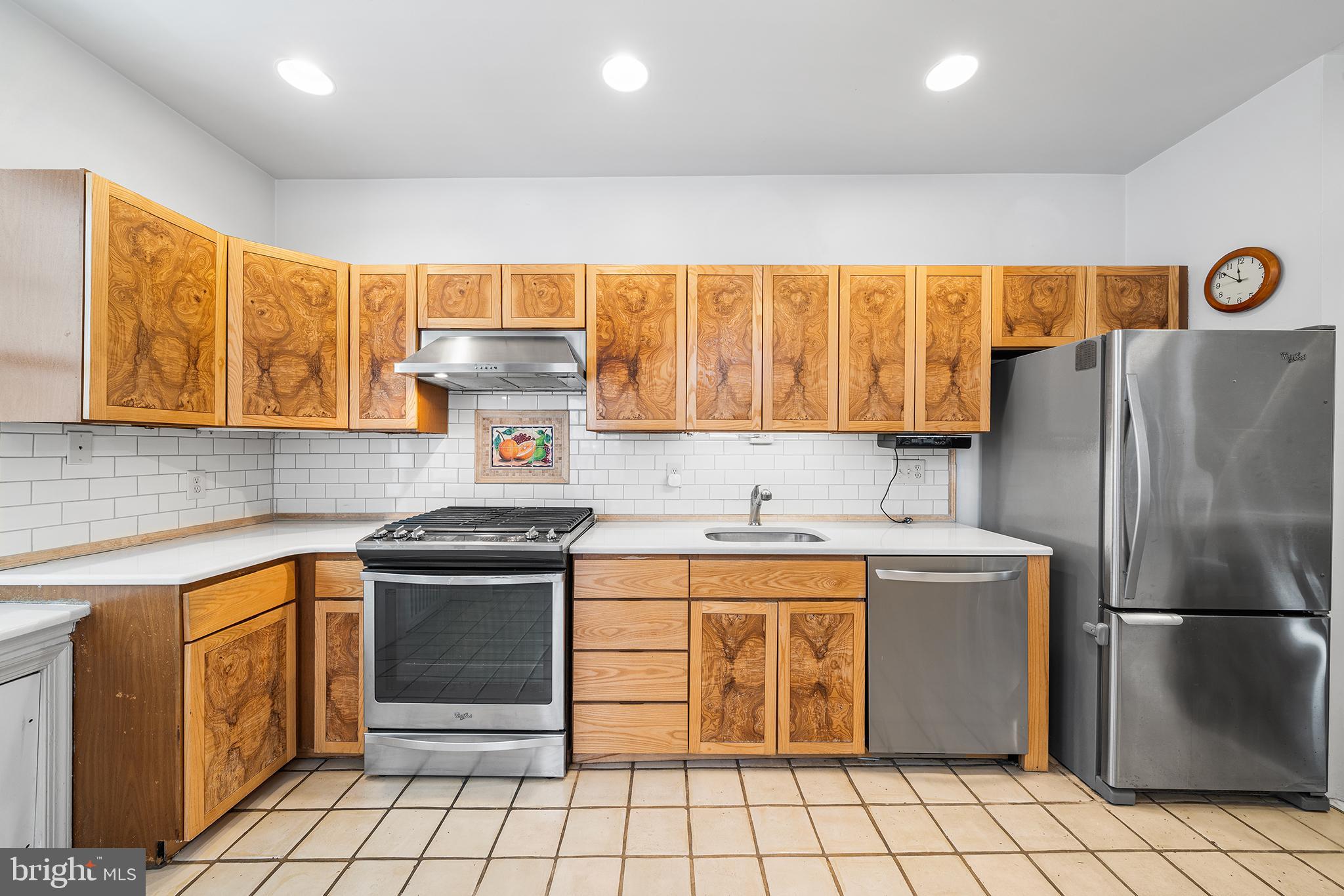 705 South Warnock Street Philadelphia, PA 19147 - Photo 10 of 28 a kitchen with stainless steel appliances granite countertop a stove a refrigerator a sink and white cabinets