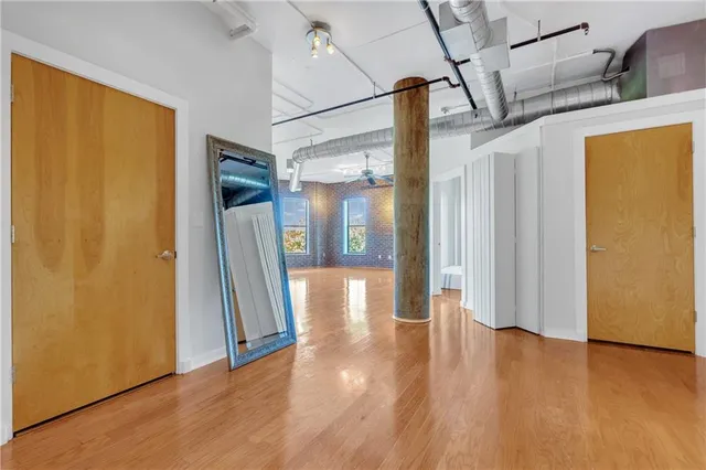 a view of a hallway with wooden floor and door