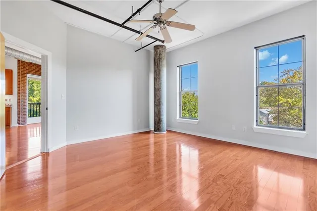 a view of a big room with wooden floor and windows
