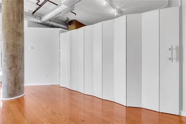 a view of empty room with wooden floor