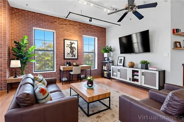 a living room with furniture a flat screen tv and a window