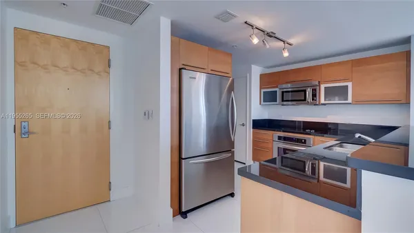 a kitchen with stainless steel appliances a refrigerator and a stove top oven