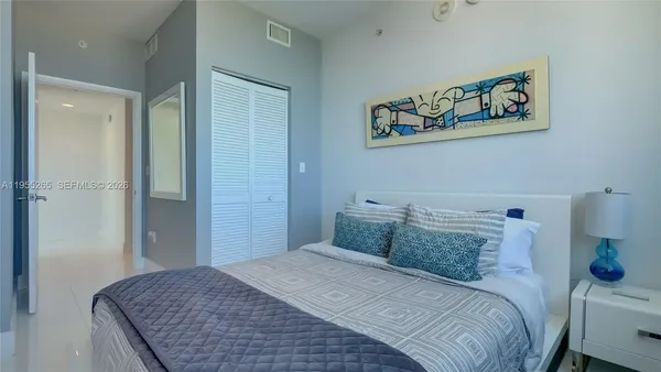 a bedroom with a bed and a painting on the wall