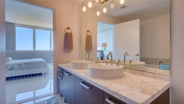 a bathroom with a granite countertop sink and a mirror