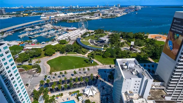 an aerial view of a city with lots of residential buildings ocean and mountain view in back