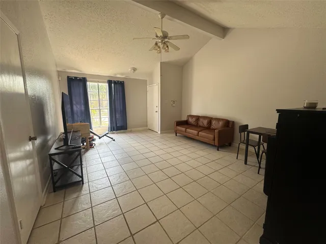 a living room with furniture a chandelier and a window