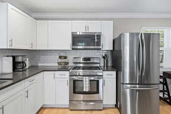 a kitchen with cabinets stainless steel appliances and a counter space
